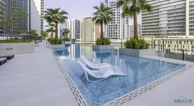 a swimming pool with a white chair on a building at Plush Studio at The Sterling East House Business Bay by Deluxe Holiday Homes in Dubai