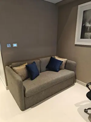 a couch in a room with blue pillows on it at LeModCasa - Luxury smart Studio with Canal View Business Bay in Dubai