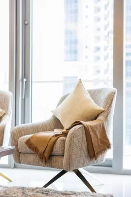 a chair with a blanket on it in a living room at Stylish 2BR at Paramount Hotel Midtown in Dubai