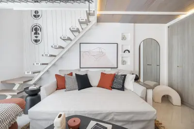 a living room with a bed and a staircase at Fashionable loft with catamaran net in JVC in Dubai