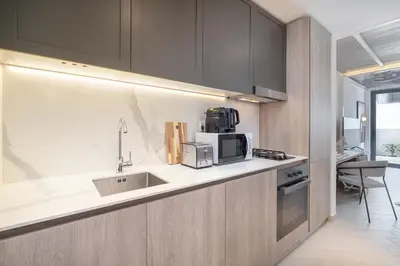 a kitchen with a sink and a microwave at Fashionable loft with catamaran net in JVC in Dubai