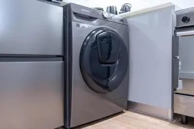 a washing machine in a kitchen next to a refrigerator at Elegant treat with Burj Khalifa view by Suiteable in Dubai