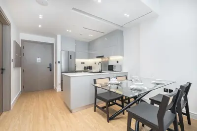 a kitchen and dining room with a table and chairs at Elegant treat with Burj Khalifa view by Suiteable in Dubai