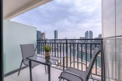 a balcony with a table and chairs and a view of the city at Serenity in Style in Zada Residence by Suiteable in Dubai