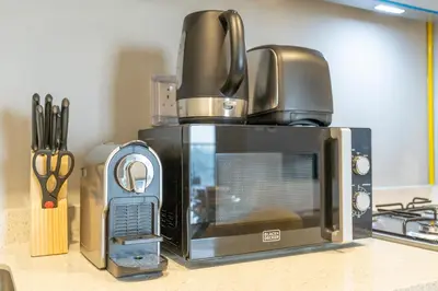 a microwave sitting on top of a kitchen counter at Serenity in Style in Zada Residence by Suiteable in Dubai