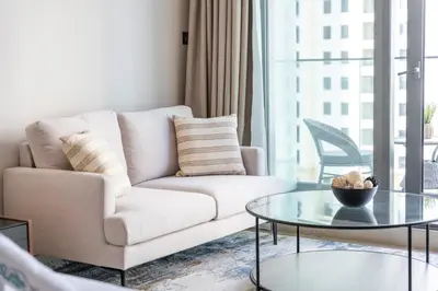 a living room with a couch and a glass table at Dive into Luxury at LIV Residence - Suiteable in Dubai