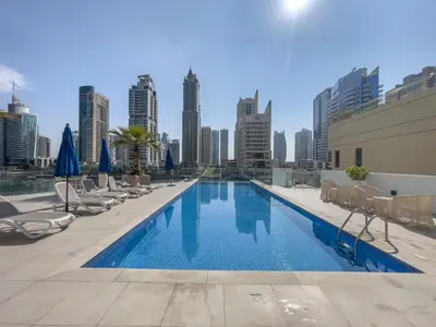 a swimming pool with chairs and a city skyline at Dive into Luxury at LIV Residence - Suiteable in Dubai