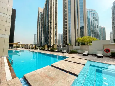 a swimming pool on the roof of a building with tall buildings at Downtown Chic Easy walk to Dubai Mall & Fountain in Dubai