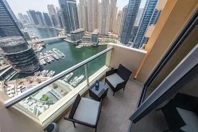 a balcony with two chairs and a view of a river at Luxury Studio with Stunning Marina & Beach Views in Dubai