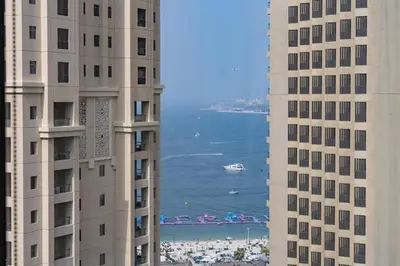two tall buildings with a view of the ocean between them at Dubai Marina Apartment with Sea view, Pool and Gym in Dubai