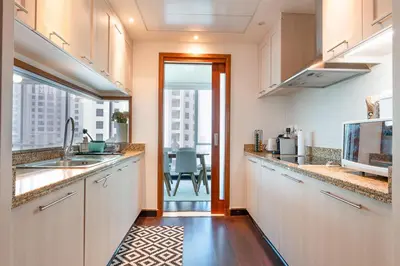 a kitchen with white cabinets and a large window at Dubai Marina Apartment with Sea view, Pool and Gym in Dubai