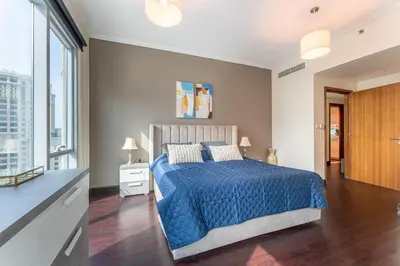a bedroom with a blue bed and a large window at Dubai Marina Apartment with Sea view, Pool and Gym in Dubai