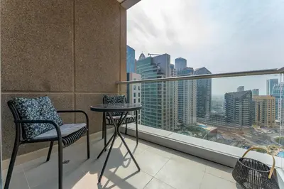 a balcony with a table and chair and a view of the city at Dubai Marina Apartment with Sea view, Pool and Gym in Dubai