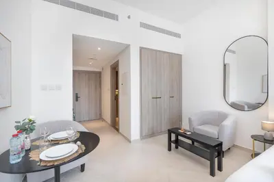 a living room with a table and chairs and a mirror at New Listing - TOP Amenities in JVC in Dubai