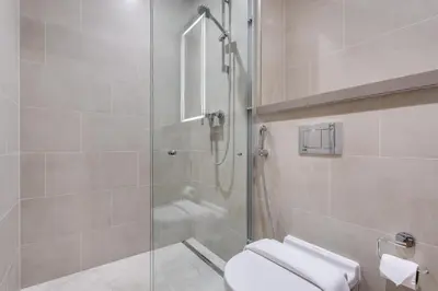 a bathroom with a shower and a toilet at STAY BY LATINEM Luxury 2BR Holiday Home W1504 near Burj Khalifa in Dubai