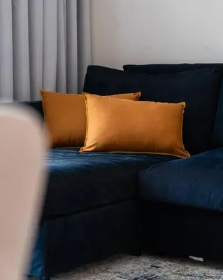 a blue couch with an orange pillow on it at 1BR •The Address Beach Residence - High floor in Dubai