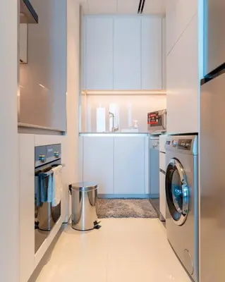 a white kitchen with a washing machine in it at 1BR •The Address Beach Residence - High floor in Dubai