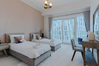 a bedroom with two beds and a desk and a window at Fantastic View l Great Amenities l Superb Location in Dubai