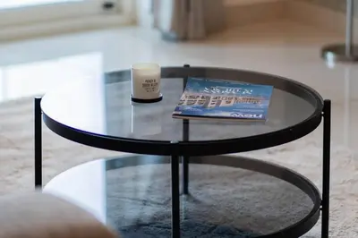 a glass table with a book and a candle on it at Fantastic View l Great Amenities l Superb Location in Dubai