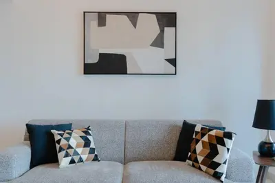 a living room with a couch with a picture on the wall at Fantastic View l Great Amenities l Superb Location in Dubai