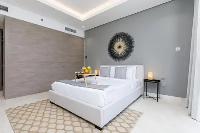a white bedroom with a large white bed and a table at Maison Privee - Classy Urban Retreat with Amazing Dubai Canal Views in Dubai