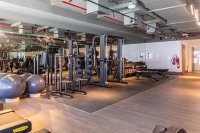 a gym with rows of exercise equipment on the floor at Maison Privee - Classy Urban Retreat with Amazing Dubai Canal Views in Dubai