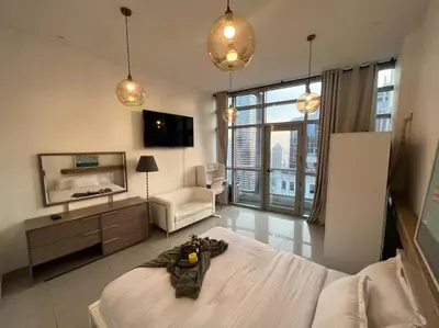 a bedroom with a large bed and a living room at Coliving Sharing Hostel ll in Dubai