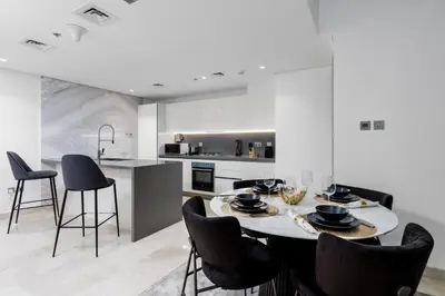 a kitchen and dining room with a table and chairs at Maison Privee - Exquisite Duplex with Private Patio & Loft Living in Dubai
