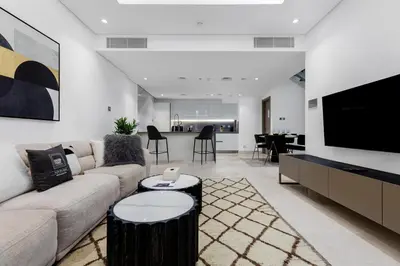 a living room with a couch and a flat screen tv at Maison Privee - Exquisite Duplex with Private Patio & Loft Living in Dubai