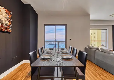 a dining room with a table and a couch at First Class Apartments in Heart of JBR, Steps to the Beach - 121 Living in Dubai