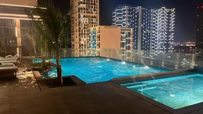 a large swimming pool on top of a building at night at Stylish Studio with Gym and Pool in Dubai