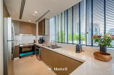 a kitchen with a sink and a counter with windows at Manzil - Luxury 4BR Penthouse with Harbour View & Private Terrace at Dubai Creek Harbour in Dubai