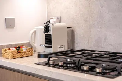 a kitchen counter with a coffee maker and a stove at YOUR STAY APARTMENTS Luxury Beachfront Living in Dubai