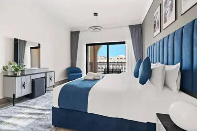 a bedroom with a large bed with a blue headboard at StoneTree - Luxurious 1BR with Beach Access in Dubai