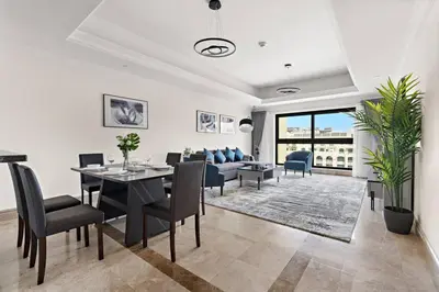 a living room with a table and chairs and a couch at StoneTree - Luxurious 1BR with Beach Access in Dubai