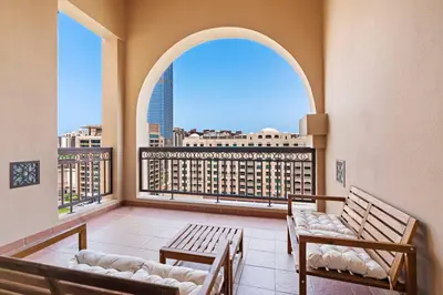 a balcony with two benches and a large window at StoneTree - Luxurious 1BR with Beach Access in Dubai