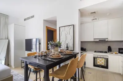 a kitchen with a dining room table with chairs at Frank Porter - Genesis by Meraki in Dubai