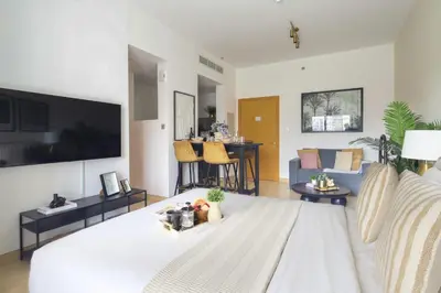 a living room with a white couch and a tv at Frank Porter - Genesis by Meraki in Dubai
