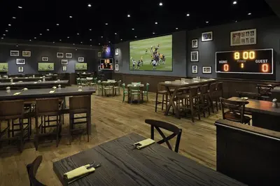 a restaurant with tables and a football game on the screen at Emaar Marina Residences - formerly Address Dubai Marina in Dubai