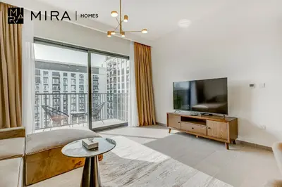 a living room with a tv and a large window at Mira Holiday Homes - Fully furnished 2 bedroom in Dubai Hills in Dubai