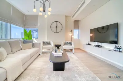 a living room with a couch and a tv at Gleeful 2BR at Sky Gardens DIFC by Deluxe Holiday Homes in Dubai