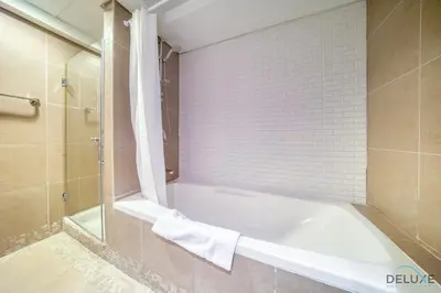 a bathroom with a bath tub and a shower at Gleeful 2BR at Sky Gardens DIFC by Deluxe Holiday Homes in Dubai