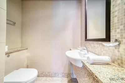 a bathroom with a sink and a toilet and a mirror at Amazing 2BR at Sky Gardens DIFC by Deluxe Holiday Homes in Dubai