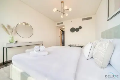 a bedroom with a large white bed and a mirror at Amazing 2BR at Sky Gardens DIFC by Deluxe Holiday Homes in Dubai