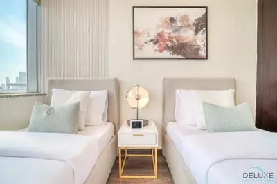 two beds in a room with a side table at Amazing 2BR at Sky Gardens DIFC by Deluxe Holiday Homes in Dubai