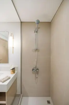 a white bathroom with a shower and a sink at Luxury Dubai Creek Balcony & View in Dubai