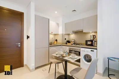 a kitchen with a table and a washing machine at Sleek One Bed Sobha Creek Vistas Reserve Tower A in Dubai