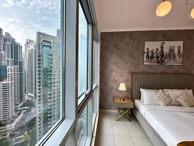 a bedroom with a bed and a large window at Lux BnB I The Residences I Sky Line Views in Dubai