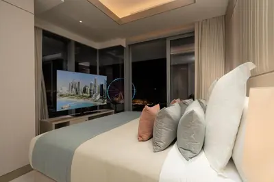 a bedroom with a bed with pillows and a television at FIVE LUXE in Dubai