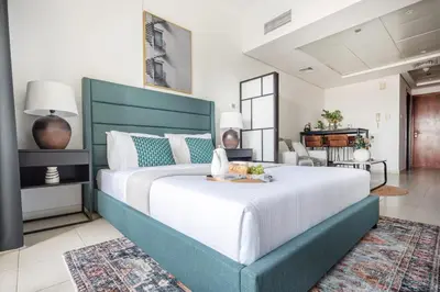 a large bedroom with a large bed with a green headboard at Frank Porter - Lake View Tower in Dubai